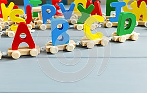 Close up Multicolored wooden letters with ABC on gray background. Set of toys for studying alphabet. Education, back to school