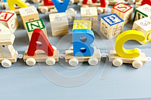 Close up Multicolored wooden letters with ABC on gray background. Set of toys for studying alphabet. Education, back to school