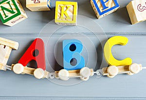 Close up Multicolored wooden letters with ABC on gray background. Set of toys for studying alphabet. Education, back to school