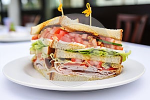 close-up of a multilayered clubhouse sandwich on a white plate