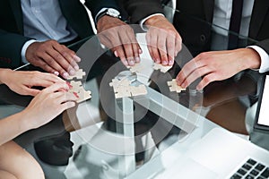 Close up .multinational business team assembling puzzle.