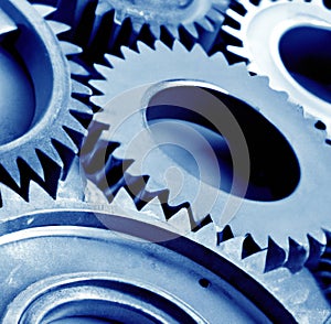 Close up of multiple blue cogs and gears on blue background