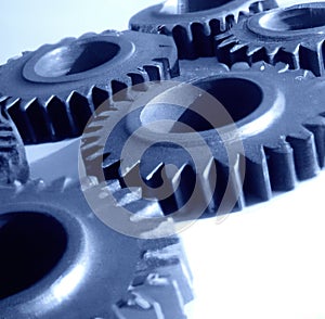 Close up of multiple blue cogs and gears on white background