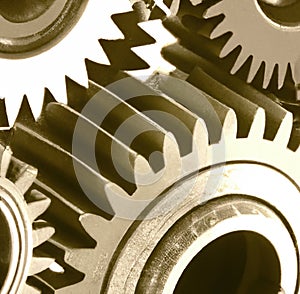 Close up of multiple brown cogs and gears on white background