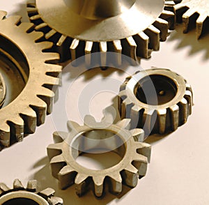 Close up of multiple brown cogs and gears on white background