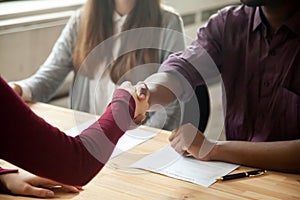 Close up of multiracial handshaking at job interview