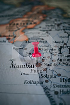 Close up of Mumbai pin pointed on the world map with a pink pushpin