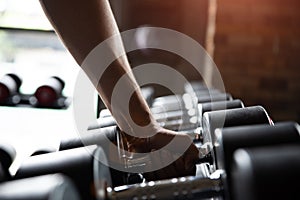 Close up muscular arm. Man hand holding dumbbell