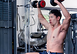 Close up of Muscular bodybuilder guy doing exercises with dumbbells.Young male fitness model lifting weights ,shirtless powerful