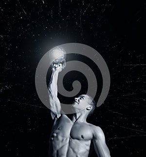Close up of muscular bodybuilder guy doing exercises with weights over black background.