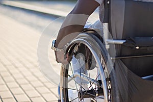 Close-up of muscular male arm rolling wheelchair wheel