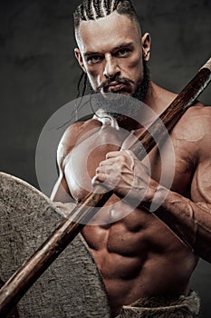 Close up of muscular viking with axe and shield in studio