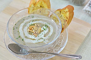 Close-up mushroom cream soup served with garlic bread on cutting