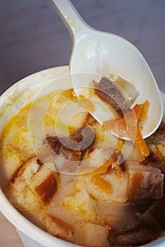 Close-up of mushroom soup in a paper glass. Takeaway food in the restaurant. The concept of vegetarian fast food in the meal
