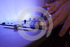 Close up of a music dj mixing tracks on his electronic console