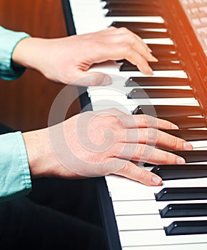 Close-up of a music performer`s hand playing the piano, man`s ha