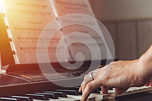 Close-up of a music performer`s man hand playing the piano from side