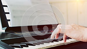 Close-up of a music performer`s man hand playing the piano from side
