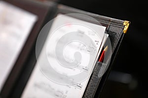 close up of a music score sheet in a black leather folder with pencil