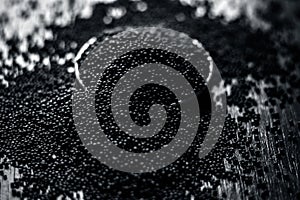 Close up of mustard seeds/Rai or brown mustard seeds in a small plate on a wooden surface in dark Gothic colors.