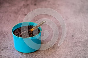 Close up of mustard seeds/Rai or brown mustard seeds in a small bowl on background, selective focus
