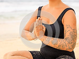 Close up namaste mudra. Yoga at the beach. Woman sitting on sand practicing yoga with namaste mudra. Meditation and concentration