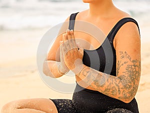 Close up namaste mudra. Yoga at the beach. Woman sitting on sand practicing yoga with namaste mudra. Meditation and concentration