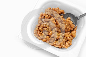 Close up of Natto or Fermented Soybean with stainless spoon isolated on white background. Traditional food in Japan. Ready to eat