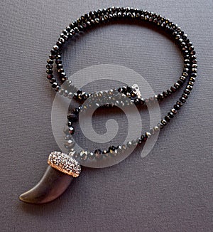 Close up of a necklace made of black crystals on a black surface