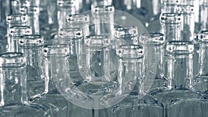 Close up of necks of vitreous bottles which are moving forward.