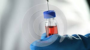 Close up of a needle drawing up the MMR vaccine from a vial to prevent measles, mumps, and rubella