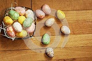 Close up on nest with Easter eggs, fee laying outside on wooden background