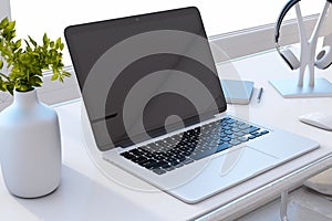 Close up of new designer office desktop with black mock up computer monitor, reflections, decorative vase with plant, other