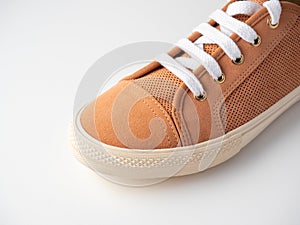 Close-up of new light brown sneakers with white laces on a white background. Nubuck suede leather