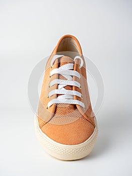 Close-up of new light brown sneakers with white laces on a white background. Nubuck suede leather