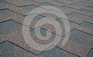 Close up on new roof asphalt shingles texture background after repair
