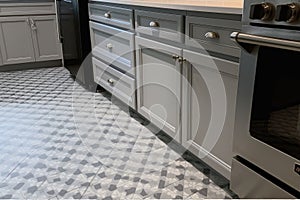 close-up of new tile floor in kitchen, with fresh and modern appliances