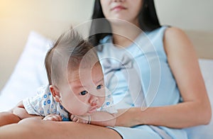 Close up newborn baby boy lying on mother legs