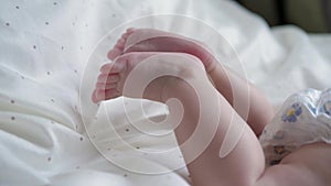 Close Up Of A Newborn Baby Dangling Small Feet With Fingers In The Crib