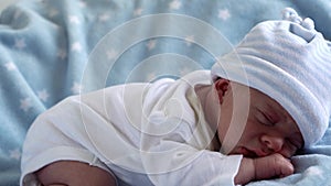 Close-up Newborn Baby Face Portrait Early Days Sleeping Sweetly On Tummy Blue Star Background. Child At Start Minutes Of