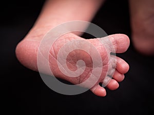 Close up of newborn baby feet covered with the blanket