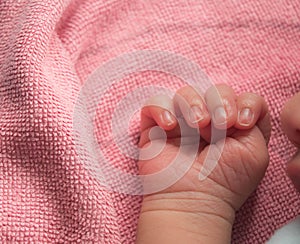 Close up newborn baby hand on pink blanket ,new family member sleeping with his mother look cutes.