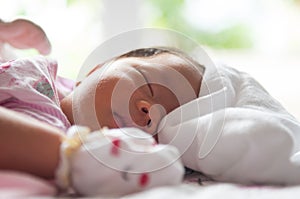 Close up newborn face with sun light. A part of face. Newborn is sleeping