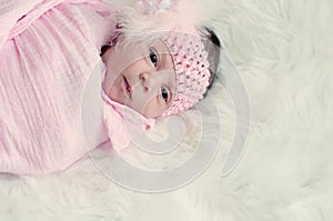 Close up of newborn girl in pink blanket.
