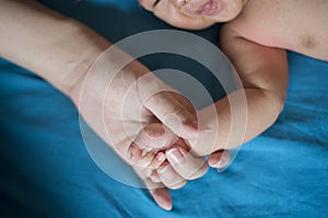 Close up of newborn hand in the hand of mother while sleeping