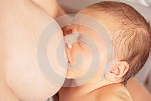 Close-up of newborn infant a baby breastfeed from mother photo
