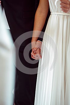 Close-up of newlweds hands holding each other tightly