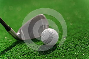 Close-up niblick and white ball for golf on the green grass. Empty right side for text of advert for golf clubs. Playing