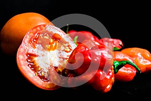 Close up of Nigerian sliced tomatoes pepper Atarodo isolated on Black Background. Red SCOTCH BONNET PEPPERS on black background