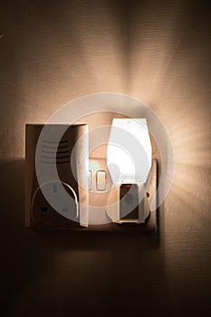 Close up of a night light plugged into a wall in a house